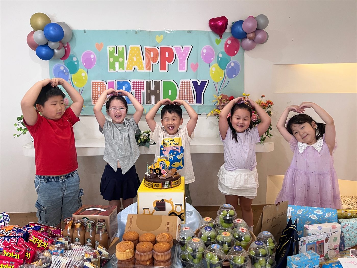 생일 파티에서 손으로 하트를 만들며 웃는 이와스 어학원 아이들
